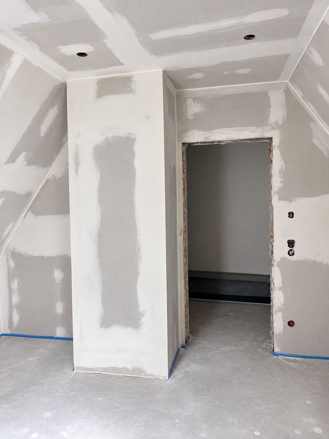 Dachgeschoss mit neuer Trockenbauwand und Türöffnung, gespachtelt