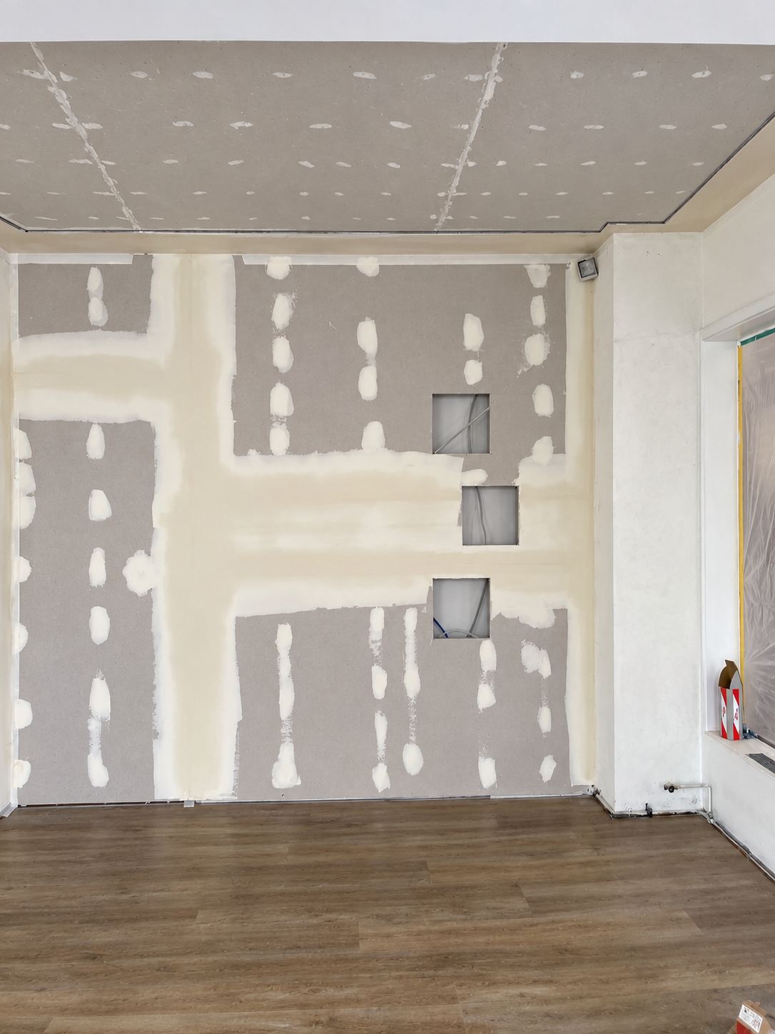 Gespachtelte Gipsplattenwand mit eingelassenen Nischen und neu beplankter Decke