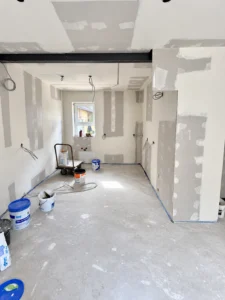 Innenausbau mit verkleidetem Deckenträger und gespachtelten Gipsplattenwänden